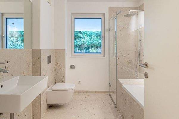 Das Tageslicht-Badezimmer mit Badewanne und Regendusche