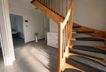 Warmer minimalistischer Flur mit Holztreppe
