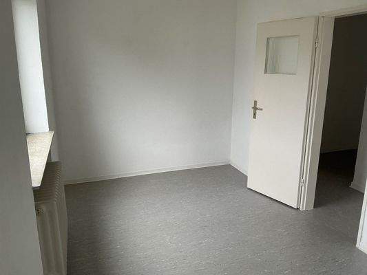 Zimmer 2 mit grauem PVC-Boden und weißen Wänden