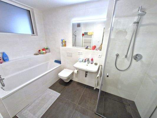 feines Tageslichtbad mit Wanne und bodengleicher Dusche