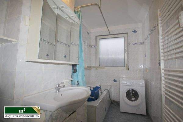 Badezimmer mit Wanne und Waschmaschine