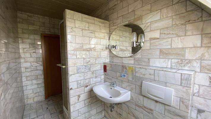 raumhoch mit Marmor gefliestes Bad