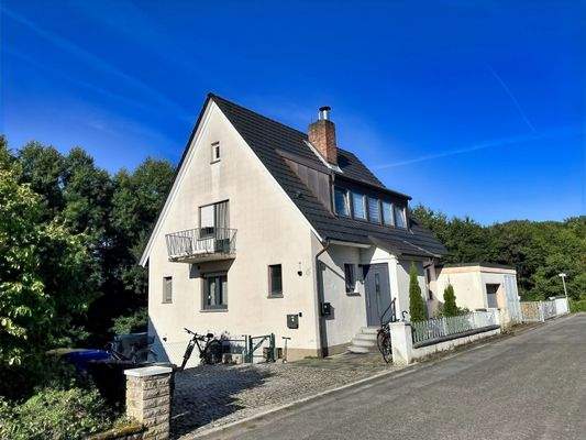 Nordostansicht mit Balkon, Hauseingang und Kfz-Stellplätzen