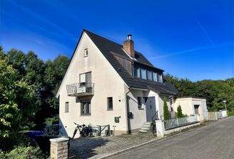 Nordostansicht mit Balkon, Hauseingang und Kfz-Stellplätzen