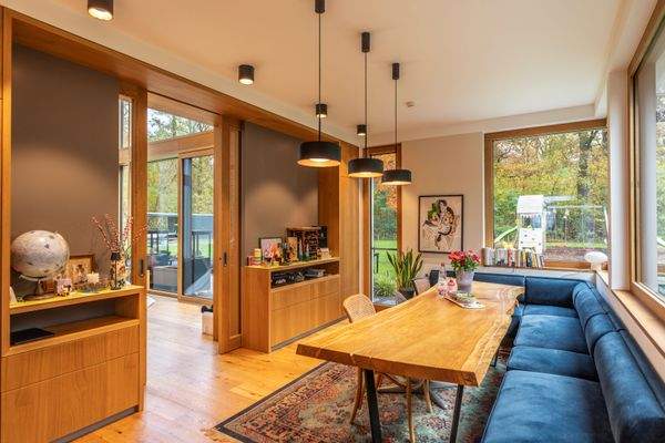 Geschmackvoll gestalteter Essbereich mit großem Holztisch und Zugang zum Wohnbereich