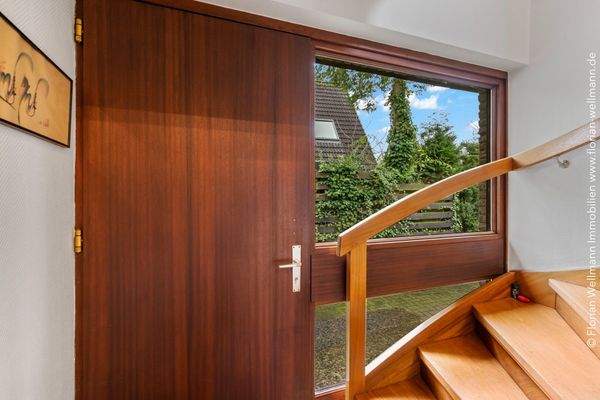 Windfang im Eingangsbereich mit Echtholztreppe ins Dachgeschoss.