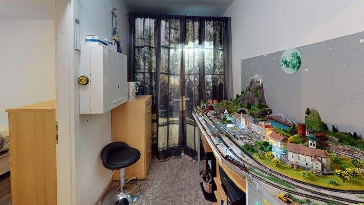 Zwischenraum zwischen Wohnzimmer und Schlafzimmer. Hinter dem Vorhang befinden sich Regale