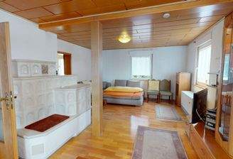 großes Wohnzimmer mit modernem Kachelofen, Echtholzparkett