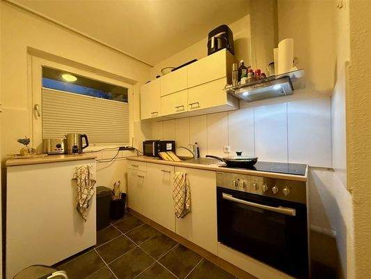 Küche mit Einbauküche und Fenster