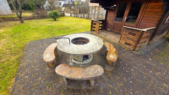Steintisch mit Bänken und Grill in der Mitte