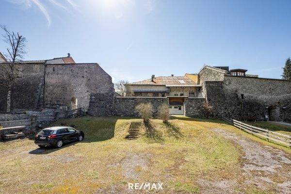Grund mit Stadtmauer und Haus dahinter