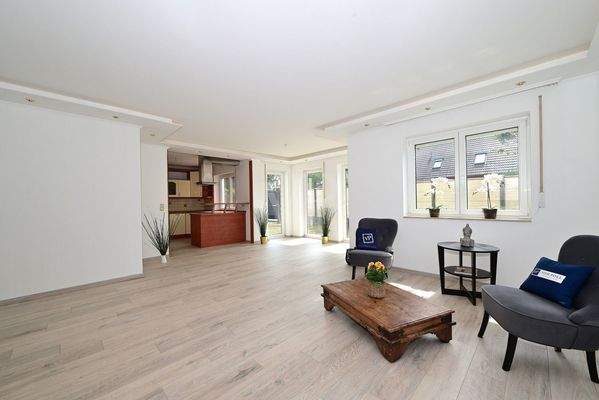 Wohnzimmer mit Blick zur offenen Einbauküche