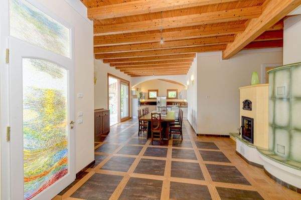 Essbereich mit Kachelofen und Blick in die Küche 