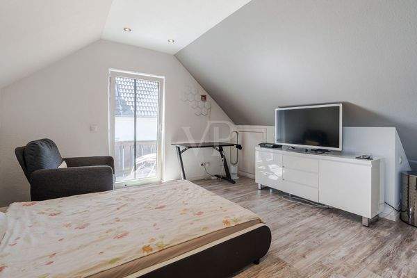 Schlafzimmer mit Balkonzugang im Dachgeschoss