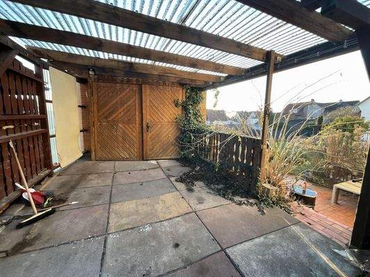 überdachte Hoffläche mit Zugang zur Gartenterrasse