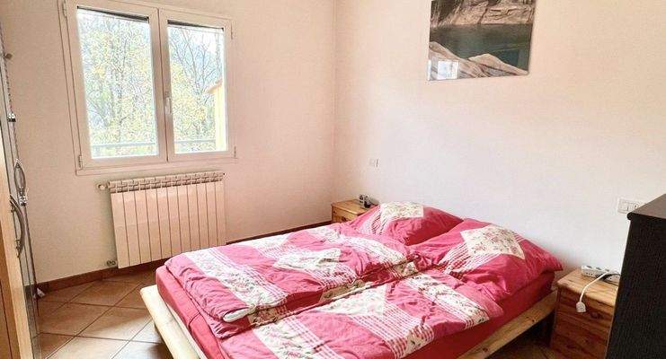 Schlafzimmer mit Doppelbett und Blick ins Grüne
