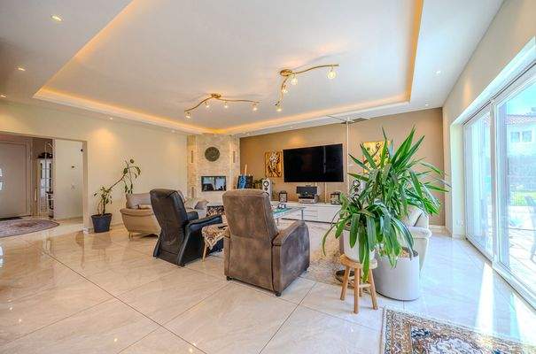 Wohnzimmer mit Kamin und Zugang zur Terrasse