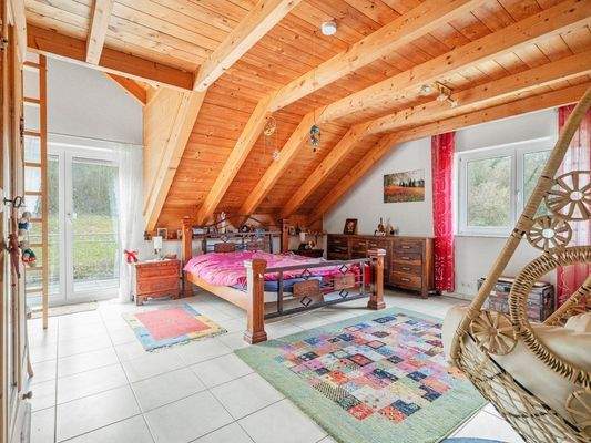 Schlafzimmer mit Balkon im Dachgeschoss