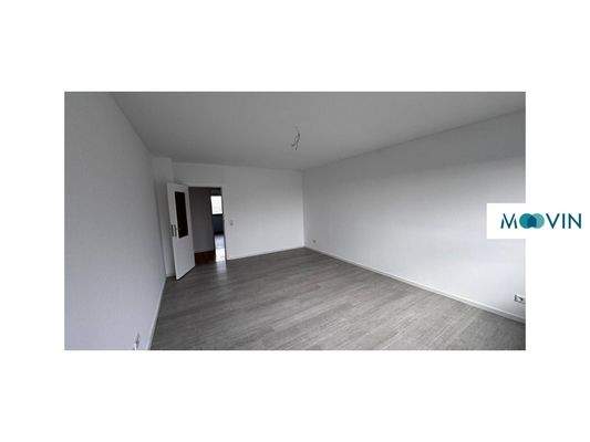 Ansicht II: Großzügiges Wohnzimmer mit Zugang zum Balkon