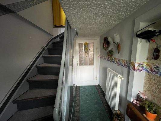 Flur mit massiver Holztreppe in das Obergeschoss