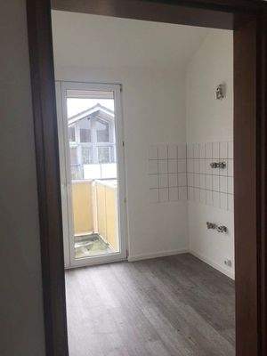 Küche mit weißem Fliesenspiegel und Zugang zum Balkon.jpg