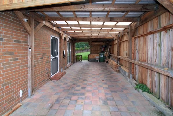 Carport mit Wallbox, Schuppen und Zugang zum HWR