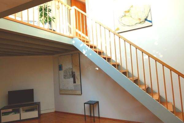 Open living-dining area with stairs leading to the gallery