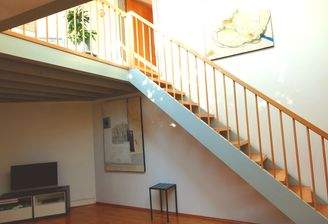 Open living-dining area with stairs leading to the gallery