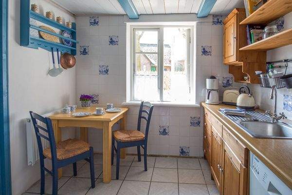 Landhausküche der Einliegerwohnung mit anschließendem Esszimmer.