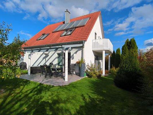 Gartenseite mit Terrasse und Balkon