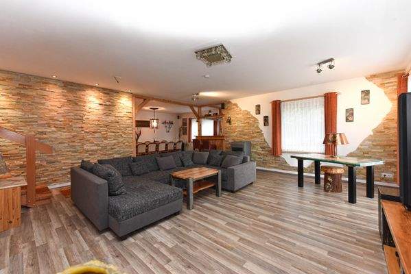 offener Wohn- und Essbereich mit dekorativen Steinwänden