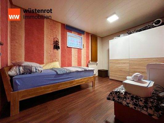 Einliegerwohnung: Schlafzimmer 2 mit farbigen Wänden, gemütlichem Bett – ein Rückzugsort