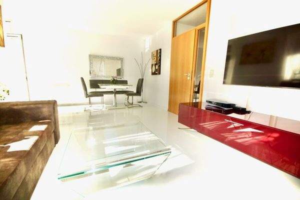 Wohnzimmer mit bodentiefen Fenstern und Zugang zur Süd-Ost-Terrasse