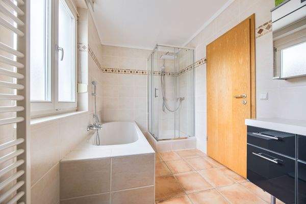 Tageslichtbadezimmer mit Waschtisch, Wanne und separater Dusche im 1. Obergeschoss
