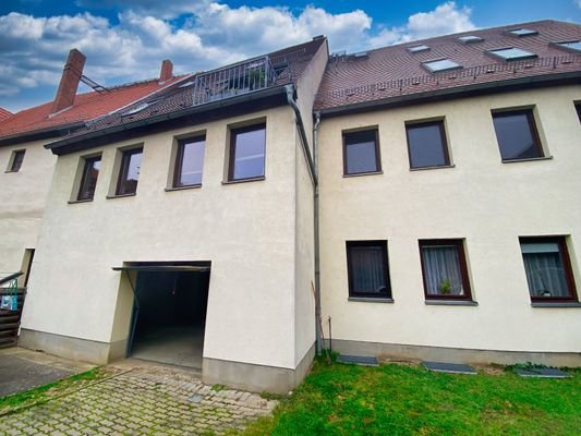 Rückseite Mehrfamilienhaus mit Garagenzugang