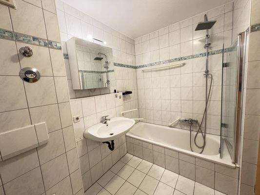 Badezimmer mit Badewanne und Duschverkleidung