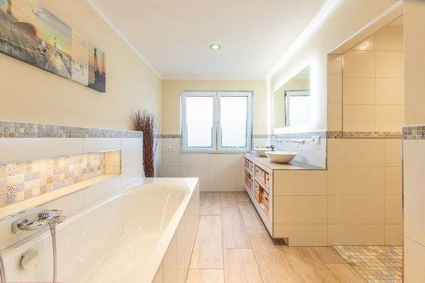 Das Hauptbadezimmer mit Doppelwaschbecken und Badewanne...