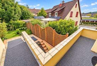 Sonniger Terrassenblick auf Garten und Haus