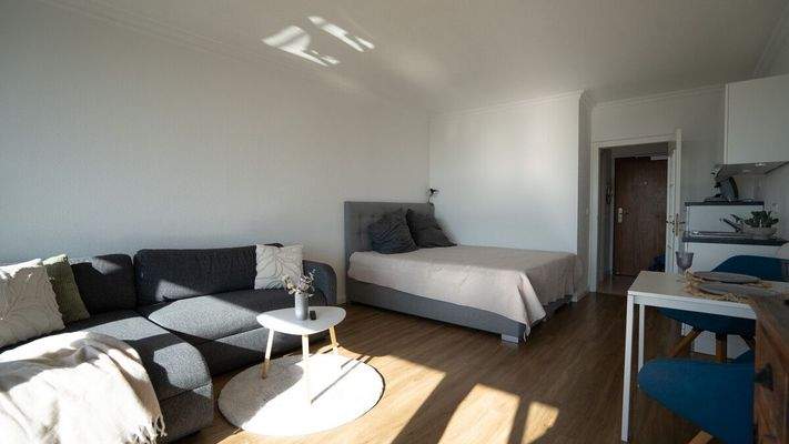 Wohnzimmer mit Platz für eine Essecke und Bett