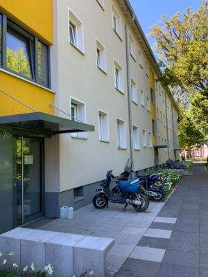 Außenansicht vorne mit Fenstern, Fassade, Eingangsbereich und Begrünung