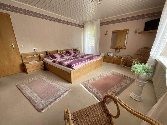 Schlafzimmer im Obergeschoss mit Zugang zum Balkon