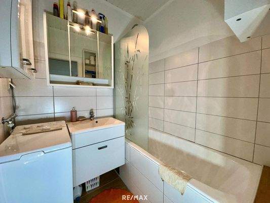 Badezimmer mit Badewanne und Waschmaschine 