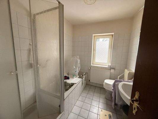 Badezimmer mit Badewanne, Dusche und Fenster