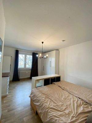 Schlafzimmer mit weißen Wänden, PVC Boden in Holzoptik und Fenster und Mietereinrichtung.jpg