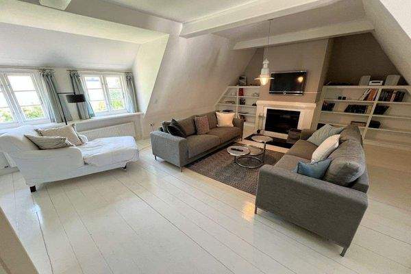 Großzügiger Wohnbereich mit Kamin im Dachgeschoss