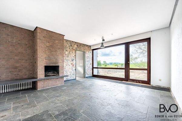 Wohnbereich mit Kamin und Zugang in den Garten