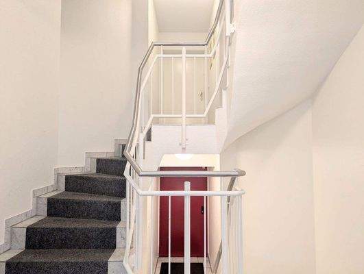 Schickes Treppenhaus mit Teppichboden.
