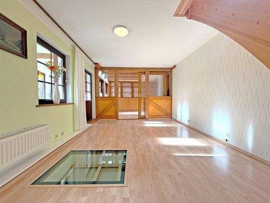 Wohnzimmer mit angrenzendem Wintergarten und Loungebereich