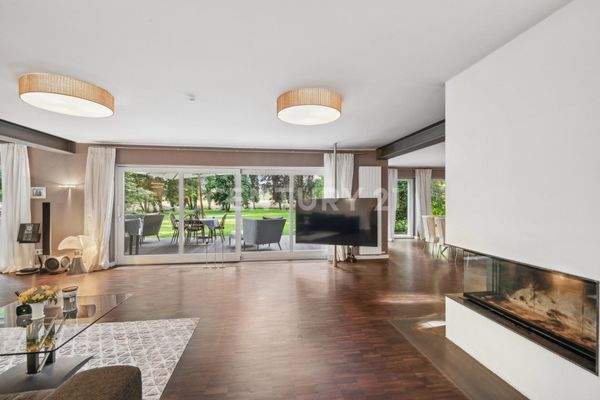 Blick von der Couch zum Kamin, Fernseher und ins Grüne