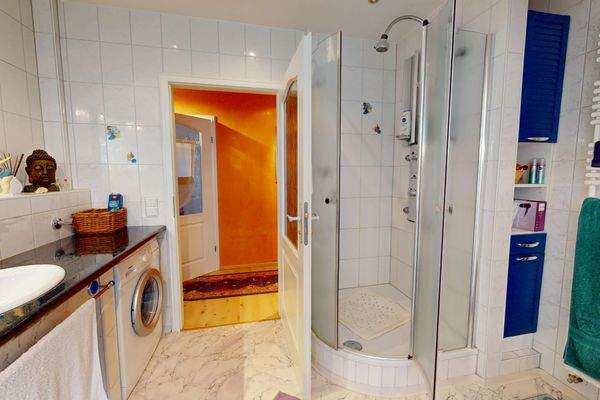 Ebenso große Dusche mit niedrigem Einstieg und Waschmaschinenanschluß im Badezimmer